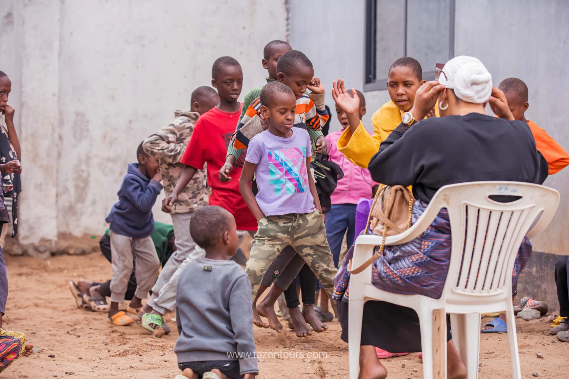 Children dancing and clapping at a Tazan Foundation event
